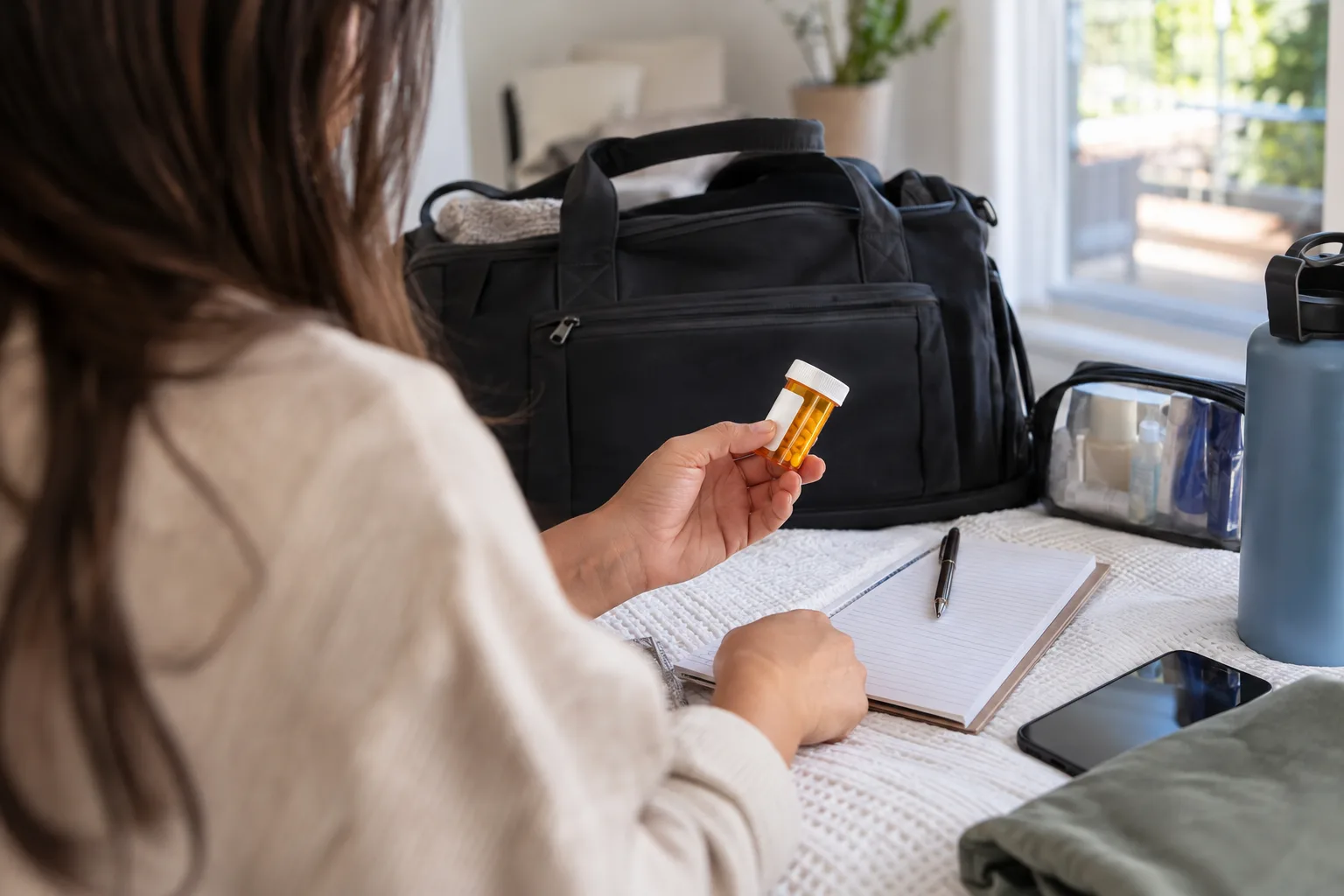 A small travel bag beside a medication list and appointment notes